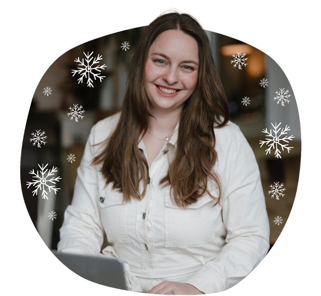 Nathalie sitzt umgeben von Schneeflocken vor dem Laptop